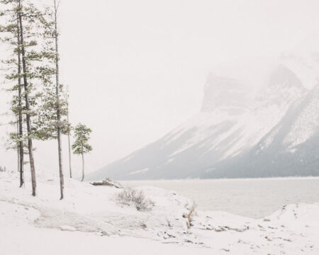 couple walking thru the snow in the mountains on bucket list trips