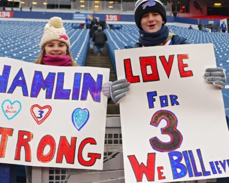 Kids hold signs to support Damar Hamlin