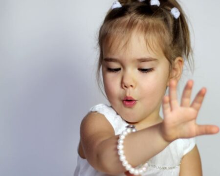 little girl looking at her bracelet birthstones by month meanings