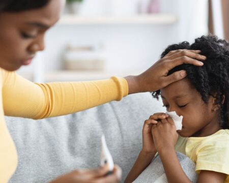 mom takes temperature of sick child with fever