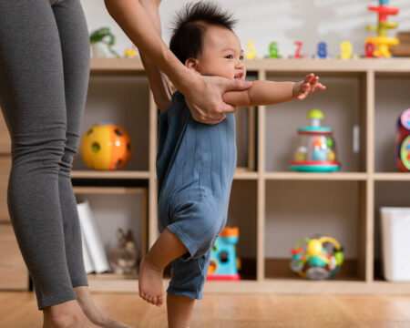 mom teaching baby to walk